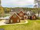 Red brick home situated with a gorgeous view of a lush lake at 170 Austin Oaks Dr, Ellenwood, GA 30294