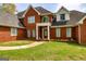 Red brick home with a covered front porch and well-maintained front yard at 170 Austin Oaks Dr, Ellenwood, GA 30294
