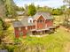 Red brick home featuring a deck and well-maintained lawn with a view of the lake at 170 Austin Oaks Dr, Ellenwood, GA 30294