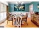 Stylish dining room features hardwood floors, a round wooden table, and a teal accent wall with unique world map art at 101 Westminster Way, Mcdonough, GA 30253