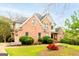 A charming brick house featuring a well-maintained lawn, lush bushes, and a cozy driveway leading to an attached garage at 101 Westminster Way, Mcdonough, GA 30253