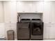 Modern laundry room with cabinets and gray appliances at 101 Westminster Way, Mcdonough, GA 30253