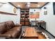 Cozy Gathering room with a leather sofa, built-in shelving, wood paneling and stylish decor at 101 Westminster Way, Mcdonough, GA 30253