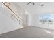 Bright living room featuring a staircase, large window, and neutral carpet at 5728 Rock Shoals Way, Atlanta, GA 30349