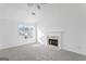 Bright living room featuring a fireplace, large window, and neutral carpet at 5728 Rock Shoals Way, Atlanta, GA 30349