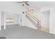 Bright living room featuring a staircase, columns, large window, and neutral carpet at 5728 Rock Shoals Way, Atlanta, GA 30349