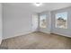 Sunlit bedroom featuring two windows offering neighborhood views and plush carpeting at 789 Galveston Way, Mcdonough, GA 30253