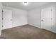 Neutral bedroom featuring carpet flooring, two white doors, and light gray walls, perfect for versatile decor at 789 Galveston Way, Mcdonough, GA 30253