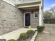 Home's front entrance featuring brick facade, dark door, and manicured landscaping at 789 Galveston Way, Mcdonough, GA 30253