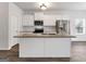 Bright kitchen features white cabinets, stainless appliances, granite countertops and a center island at 789 Galveston Way, Mcdonough, GA 30253