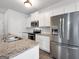 Bright kitchen features white cabinets, stainless appliances, and granite countertops at 789 Galveston Way, Mcdonough, GA 30253