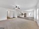 Open living room features plush carpet and view into dining room and kitchen at 789 Galveston Way, Mcdonough, GA 30253