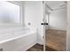 Main bathroom featuring tub under frosted glass window, next to the main bedroom at 789 Galveston Way, Mcdonough, GA 30253