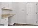 Hallway office space with built-in desk, cabinets, and a door for privacy at 789 Galveston Way, Mcdonough, GA 30253