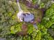 Overhead view of a home surrounded by mature trees, featuring a well-maintained roof and extended driveway at 1015 Middlebrook Dr, Mcdonough, GA 30252