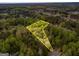 Aerial view showcasing a wooded lot outlined in yellow, surrounded by lush greenery and nearby homes at 1015 Middlebrook Dr, Mcdonough, GA 30252
