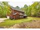 Brick house with a backyard featuring a covered patio, grassy area, and mature trees at 1015 Middlebrook Dr, Mcdonough, GA 30252