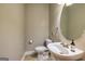 Half-bathroom with a sleek pedestal sink, modern fixtures and tile floors at 1015 Middlebrook Dr, Mcdonough, GA 30252