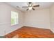 A light and airy bedroom with wood floors and a ceiling fan at 1015 Middlebrook Dr, Mcdonough, GA 30252