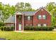 Traditional two-story brick home featuring black shutters, a gabled roof, and a well-manicured lawn at 1015 Middlebrook Dr, Mcdonough, GA 30252
