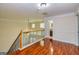 Hallway with shiny wood floors, wood railing and neutral paint at 1015 Middlebrook Dr, Mcdonough, GA 30252