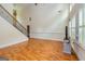 Bright living room featuring hardwood floors, a staircase and large windows with shutter blinds at 1015 Middlebrook Dr, Mcdonough, GA 30252