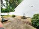 View of the backyard showing a side patio area, small decorative fountain, and white siding at 645 Crossbridge Aly, Johns Creek, GA 30022