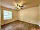 Spacious bedroom featuring modern ceiling fan, large window offering natural light and hardwood floors at 645 Crossbridge Aly, Johns Creek, GA 30022