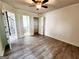 A bedroom with wood-look floors, ceiling fan, and access to a closet and en-suite bathroom at 645 Crossbridge Aly, Johns Creek, GA 30022