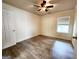A simple bedroom with wood-look floors, a ceiling fan, and a window with blinds at 645 Crossbridge Aly, Johns Creek, GA 30022