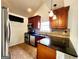 A kitchen featuring wooden cabinets, black countertops, stainless steel appliances, and tile flooring at 645 Crossbridge Aly, Johns Creek, GA 30022