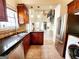 View of kitchen with stainless appliances, granite counters, wood cabinets, and open layout to living space at 645 Crossbridge Aly, Johns Creek, GA 30022
