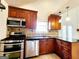 Kitchen featuring wood cabinets, stainless appliances, granite counters, and tile backsplash at 645 Crossbridge Aly, Johns Creek, GA 30022