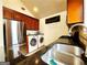 Kitchen with stainless steel appliances, granite countertops, and a convenient laundry area at 645 Crossbridge Aly, Johns Creek, GA 30022
