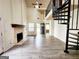 A living room with a fireplace and spiral staircase providing access to upper level at 645 Crossbridge Aly, Johns Creek, GA 30022