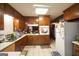 Traditional kitchen featuring stained wood cabinets, white appliances and tile floors at 3257 Greenvale Way, Decatur, GA 30034