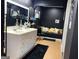 Sleek black bathroom featuring a dual sink vanity, bench seating and stylish décor at 4710 Meadowlark Se Dr, Conyers, GA 30094