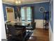 Modern dining room featuring blue walls, hardwood floors, and a black glass-top table at 4710 Meadowlark Se Dr, Conyers, GA 30094