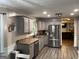 Well-lit kitchen features stainless steel appliances, gray cabinets, and wood-look flooring at 4710 Meadowlark Se Dr, Conyers, GA 30094