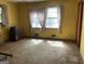Bedroom with a dresser, two windows, yellow walls, and dirty carpet at 8395 Rivertown Rd, Fairburn, GA 30213