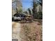 View of a home nestled among the trees with cars parked in the driveway at 8395 Rivertown Rd, Fairburn, GA 30213