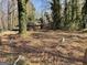 View of a home from the street, surrounded by a yard full of leaves and trees at 8395 Rivertown Rd, Fairburn, GA 30213