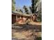 Exterior shot of a single-story brick home surrounded by mature trees and landscaping at 8395 Rivertown Rd, Fairburn, GA 30213