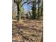 View of a brick home partially hidden among the trees, with a truck in the driveway at 8395 Rivertown Rd, Fairburn, GA 30213