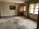 Neglected living room with dirty carpet, wood trim and natural light at 8395 Rivertown Rd, Fairburn, GA 30213