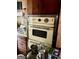 Vintage double oven with yellow finish and metal trim in a dated kitchen at 8395 Rivertown Rd, Fairburn, GA 30213