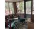 Dilapidated sunroom with broken windows, damaged screens and debris at 8395 Rivertown Rd, Fairburn, GA 30213