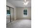 A large bedroom featuring carpet flooring and closet with mirror doors and a bright window at 7747 Roundtree Xing, Riverdale, GA 30274