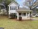 Charming two-story home featuring a covered porch and manicured front yard at 7747 Roundtree Xing, Riverdale, GA 30274