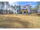 Modern farmhouse with white siding, black windows, and a spacious lawn on a sunny day at 140 Wesley Pl, Fayetteville, GA 30214